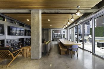 a long wooden table with chairs is in the middle of a room with large windows at The Shay, District of Columbia 20001